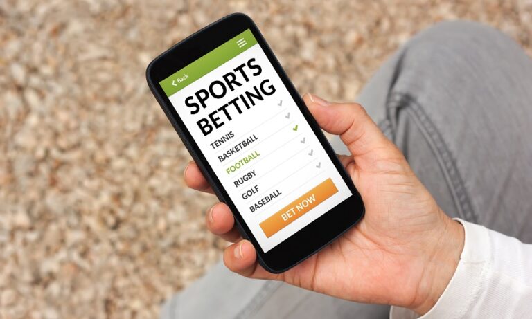 Hand holding smart phone with sports betting concept on screen