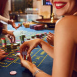 Chips in the hands of a female roulette player in casino background.