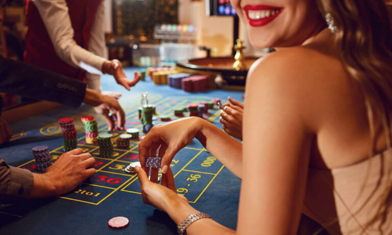 Chips in the hands of a female roulette player in casino background.